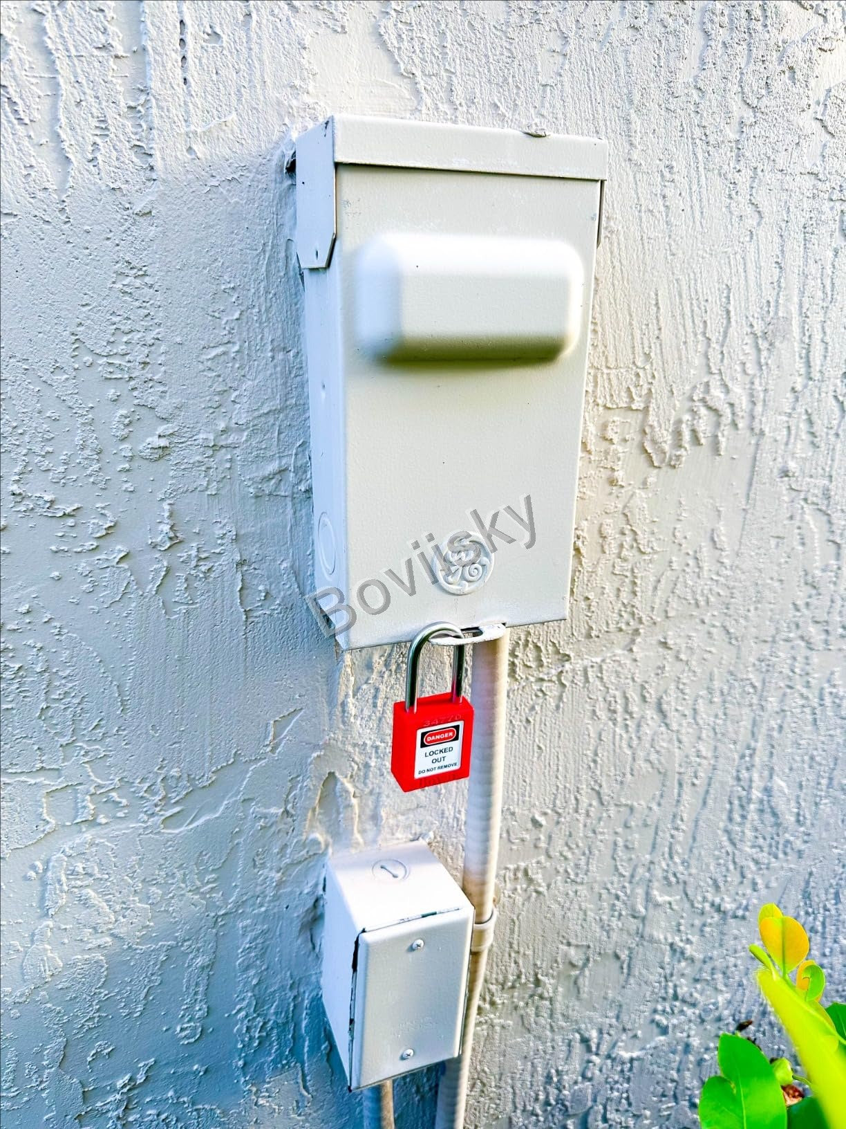 Exterior electrical disconnect locked out with a red safety padlock