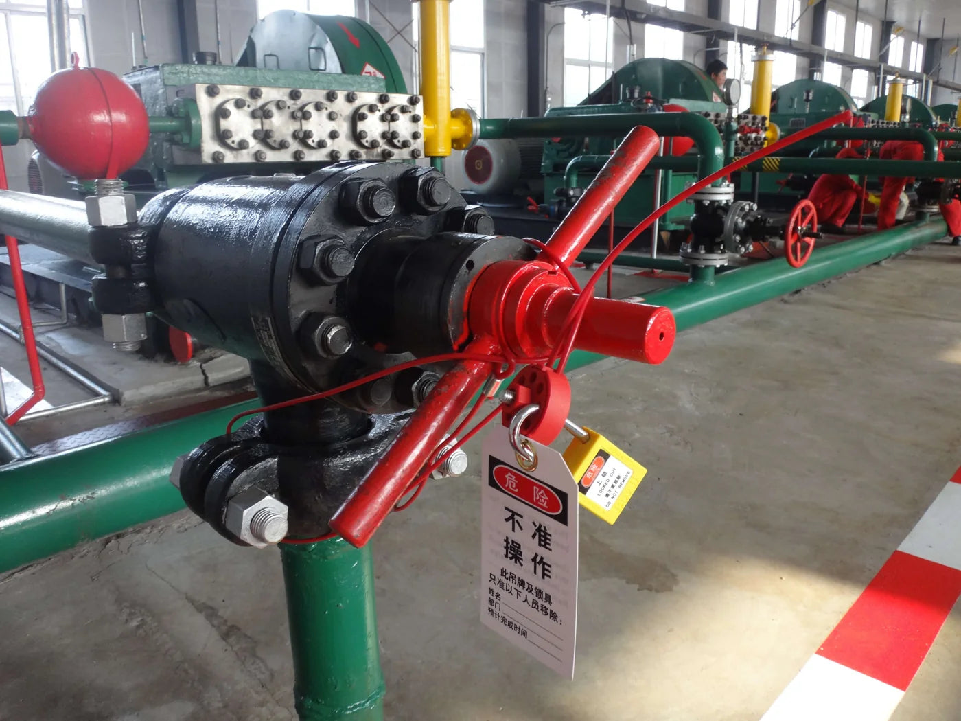 Valve secured with lockout equipment and a safety warning tag